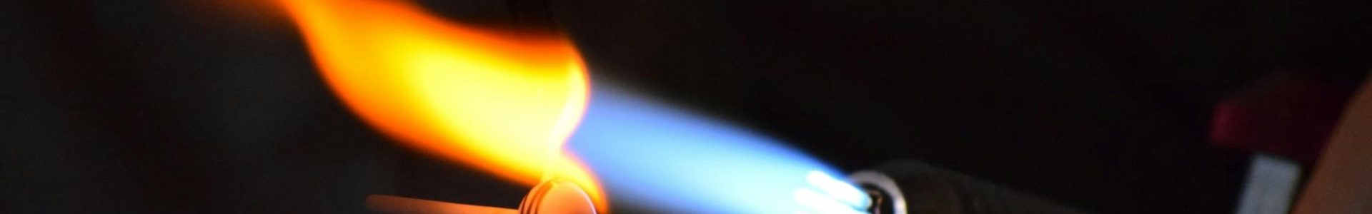 Close-up of a torch flame used in glassblowing, showcasing heat and craftsmanship.